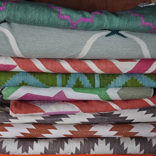 Stacked Indian dhurrie rugs at the Mahout Lifestyle's 'show shed' in north Oxfordshire.