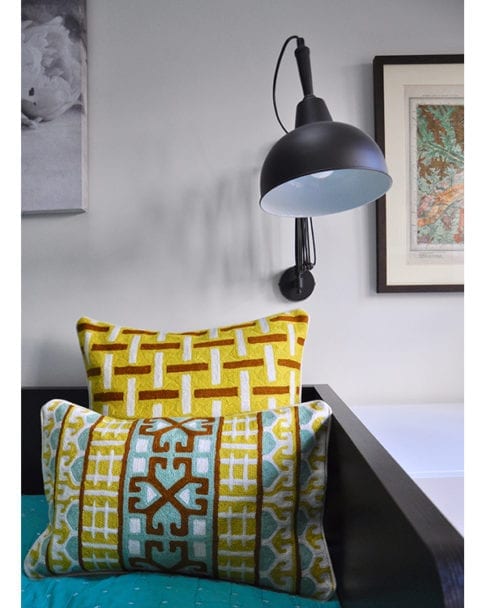 Crewel work cushion covers in turquoise and chocolate with a yellow geometric background, from Telescope Style.