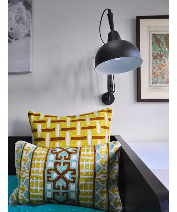 Crewel work cushion covers in turquoise and chocolate with a yellow geometric background, from Telescope Style.