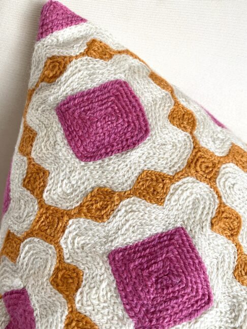 Crewelwork cushion up close showing the workmanship in pink and orange thread.