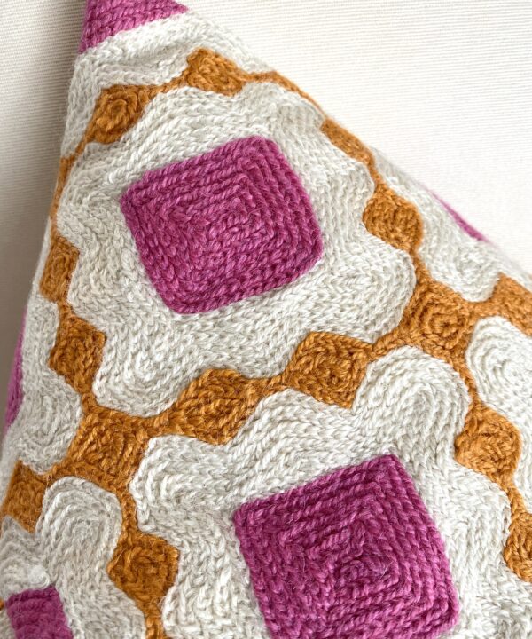 Crewelwork cushion up close showing the workmanship in pink and orange thread.