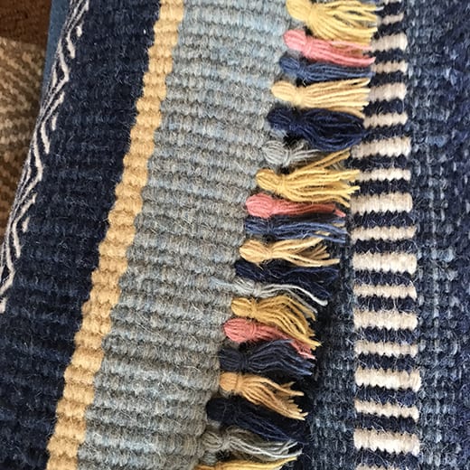 A multi-coloured tassel detail from a modern, flatweave rug.