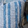 A linen striped cushion in a hand-printed, blue, zig-zag stripe design.