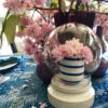 Display domes hand-crafted in Thailand, on a table with pink blossom blooms.