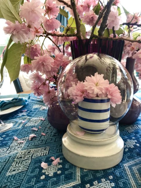 Display domes hand-crafted in Thailand, on a table with pink blossom blooms.