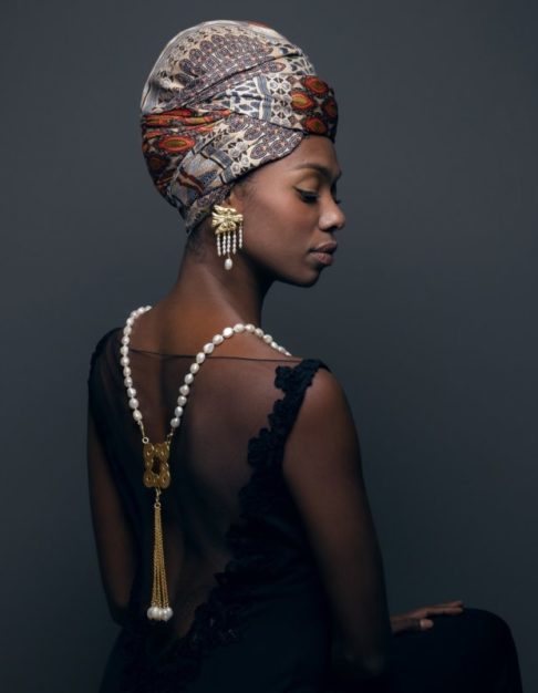 A model wearing gold and pearl jewellery inspired by Greek myths and legends.