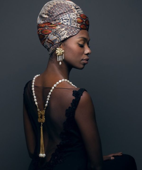 A model wearing gold and pearl jewellery inspired by Greek myths and legends.