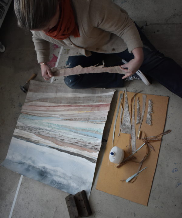 The artist, Emma Tweedie, working on the original, mixed media collage Dunes At Murlough Bay in her studio.