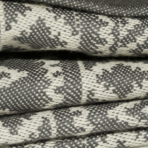 Close up detail showing the weave of a subtly patterned grey linen tablecloth.