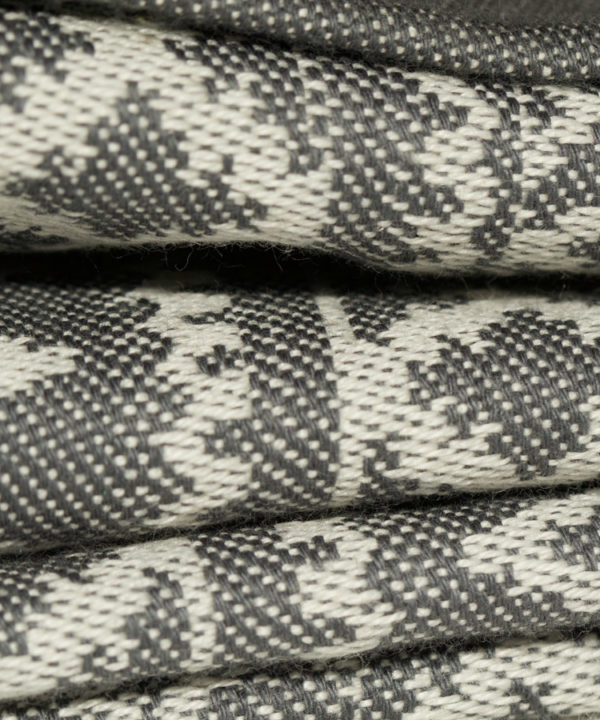 Close up detail showing the weave of a subtly patterned grey linen tablecloth.