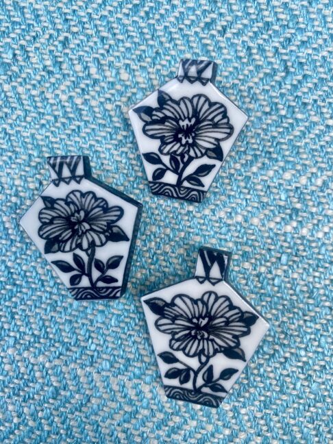 Hand-painted floral brooches in black and white.