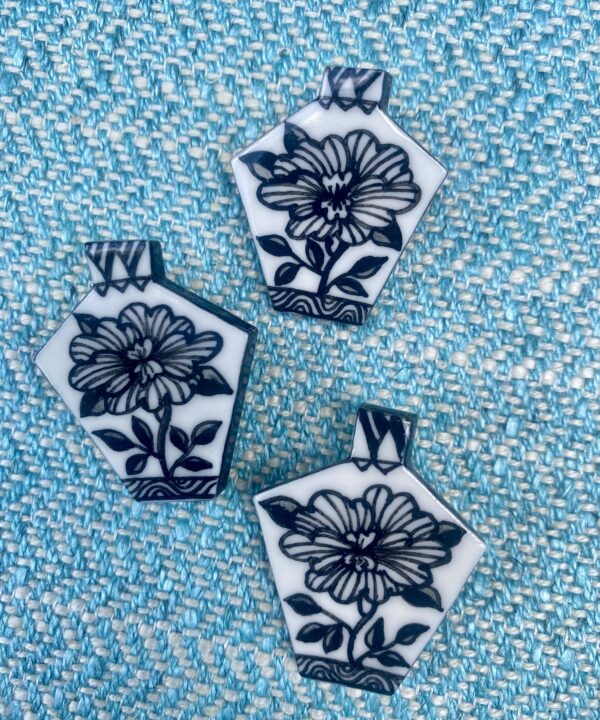 Hand-painted floral brooches in black and white.