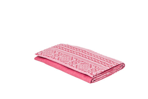 A folded, pink linen Hungarian-folk-patterned tablecloth.