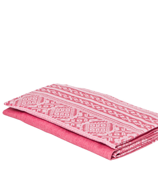 A folded, pink linen Hungarian-folk-patterned tablecloth.