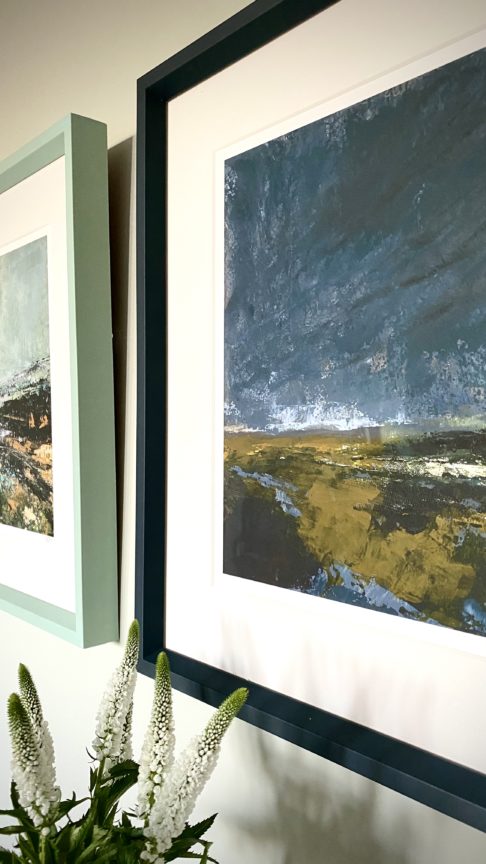 Close-up shot of a stormy Irish landscape scene print with an inky blue frame.