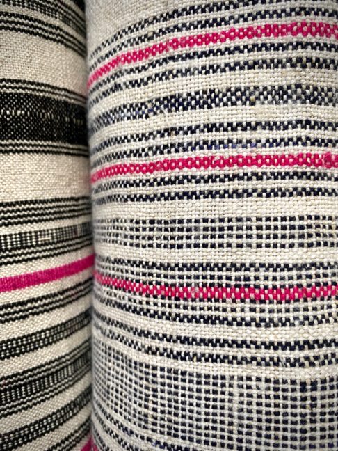 Close up shot of a black and white lampshade textile with a pink stripe.