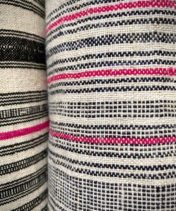 Close up shot of a black and white lampshade textile with a pink stripe.