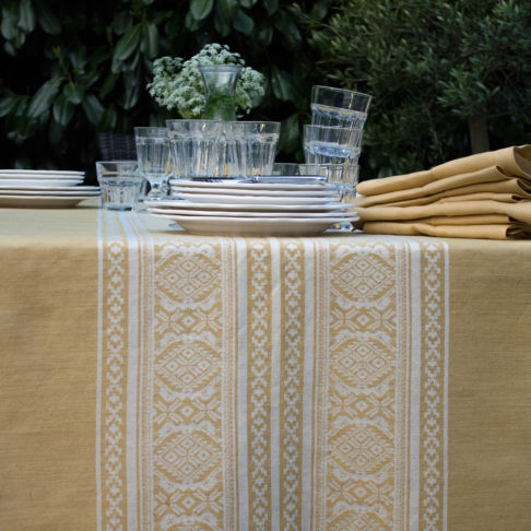 Detail of an elegant, Hungarian-folk-inspired tablecloth in soft yellow.