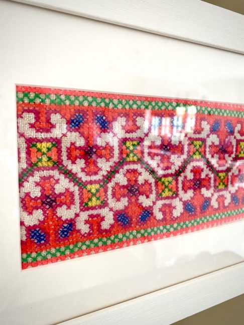 Framed fabric wall art showcasing a panel of hand-embroidered Thai textile, sourced in north of the country.