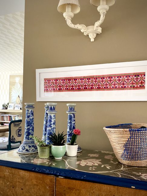 A large landscape framed vintage Thai embroidery panel shown above a sideboard.