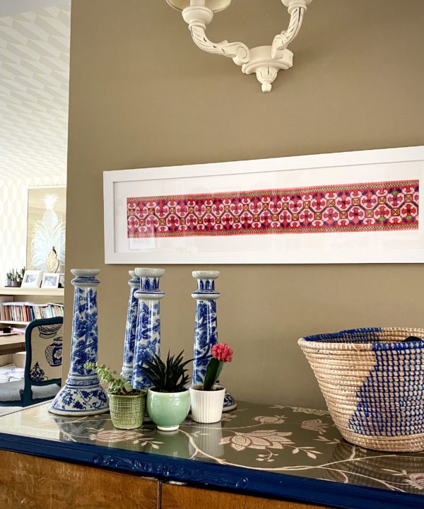 A large landscape framed vintage Thai embroidery panel shown above a sideboard.