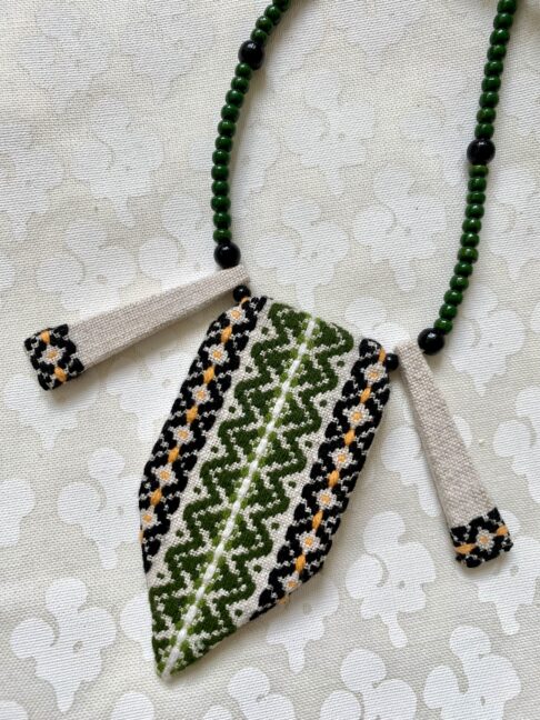 Boho statement necklace in green and black embroidered textile.