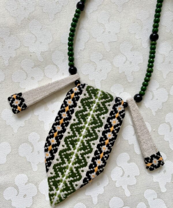 Boho statement necklace in green and black embroidered textile.