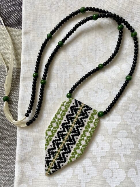 A statement green necklace handmade using vintage embroidered textiles from Slovenia.