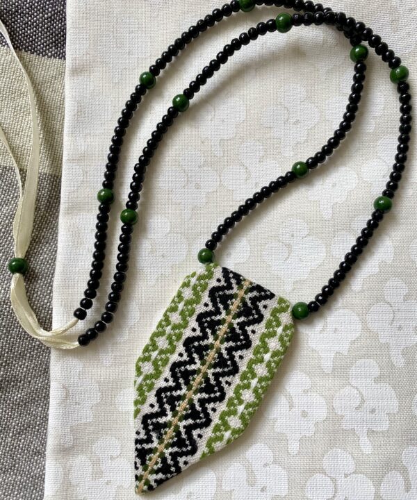 A statement green necklace handmade using vintage embroidered textiles from Slovenia.