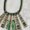 A green bib necklace showcasing a vintage Slovenian embroidered textile.