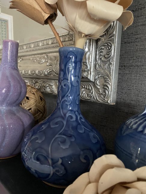 A blue ceramic bottle vase with a curling leaf design in relief, handmade in Chiangmai, northern Thailand.