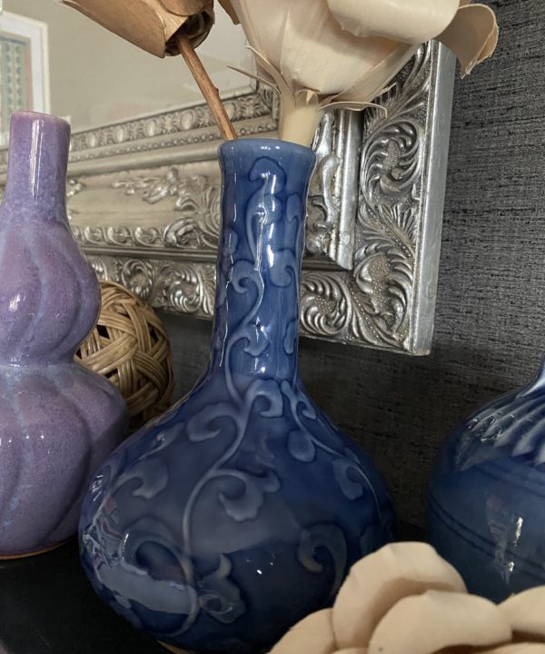 A blue ceramic bottle vase with a curling leaf design in relief, handmade in Chiangmai, northern Thailand.