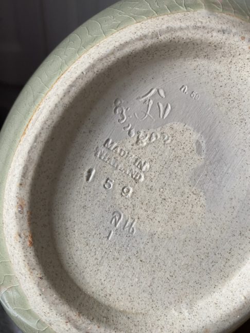 Detail of the backstamp on a handmade celadon pot from Thailand.