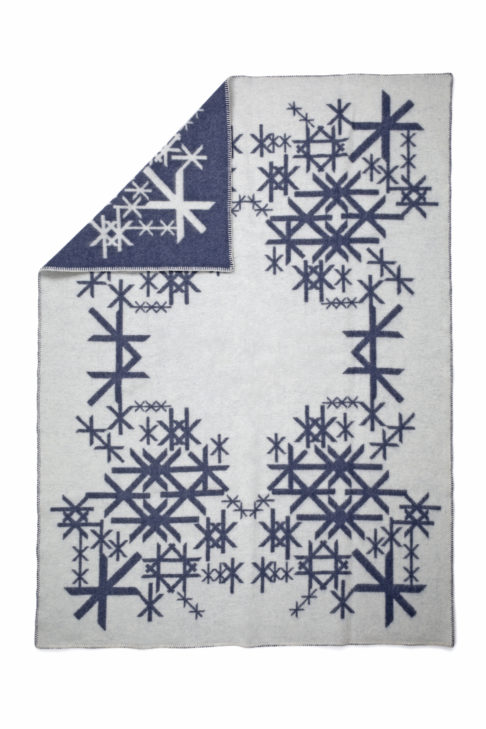 A reversible, Icelandic runes motif blanket in dark blue.