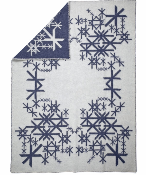 A reversible, Icelandic runes motif blanket in dark blue.