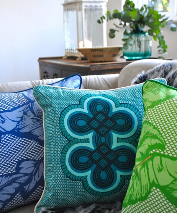 Brightly coloured African style cushions on a sofa.