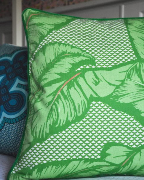 A palm print cushion in a vibrant green hue.