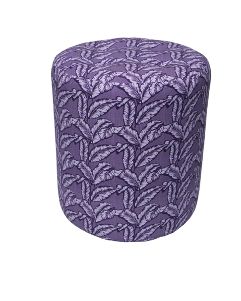 A purple upholstered dressing table stool with a tropical palm print.