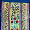 Fabric wall art showing a section of an embroidered Thai costume panel.
