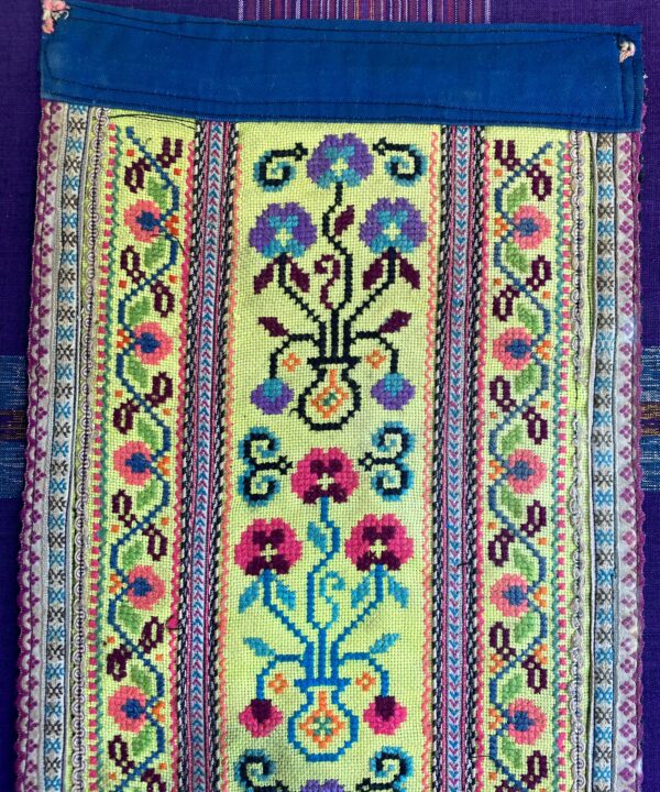 Fabric wall art showing a section of an embroidered Thai costume panel.