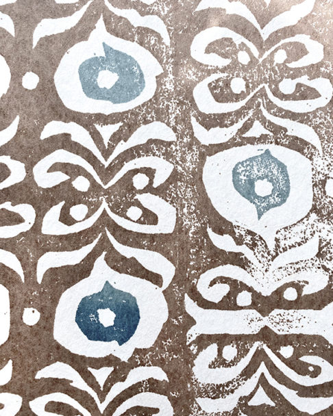 Detail shot of a brown and blue wallpaper with a Middle-Eastern inspired design.