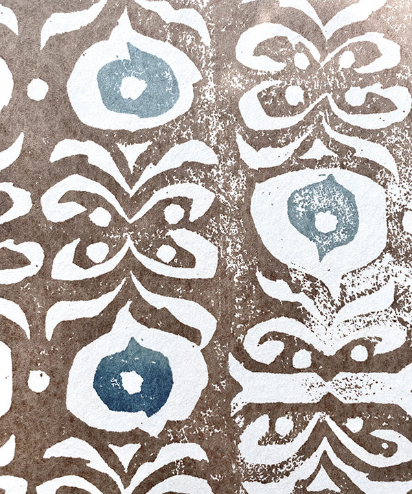 Detail shot of a brown and blue wallpaper with a Middle-Eastern inspired design.