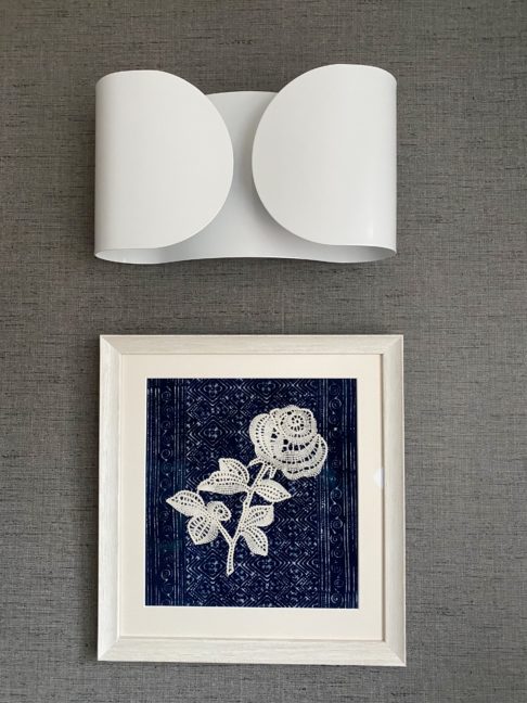 Traditional meets modernity. A bobbin lace rose, framed against Thai textiles and displayed beneath a modern Italian wall light.