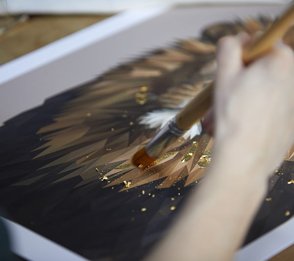 Detail shot of Talia Giles applying a gold leaf finish to the lion portrait.