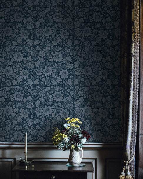 Folk art wallpaper with a modern twist in a deep grey/blue hue.