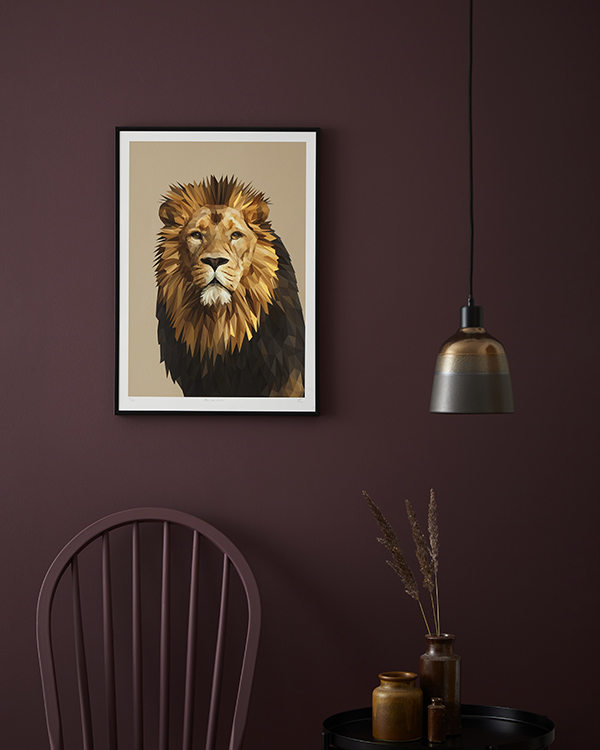 A majestic lion portrait is displayed against a deep aubergine painted wall.