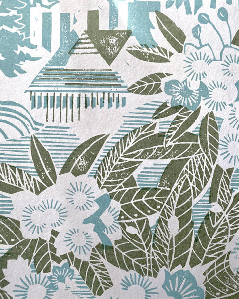 Detail of a country garden wallpaper in a soft peacock blue hue with sage green accents.