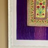 Fabric wall art comprising a vintage embroidered panel from northern Thai craftspeople framed against South East Asian dress cotton.