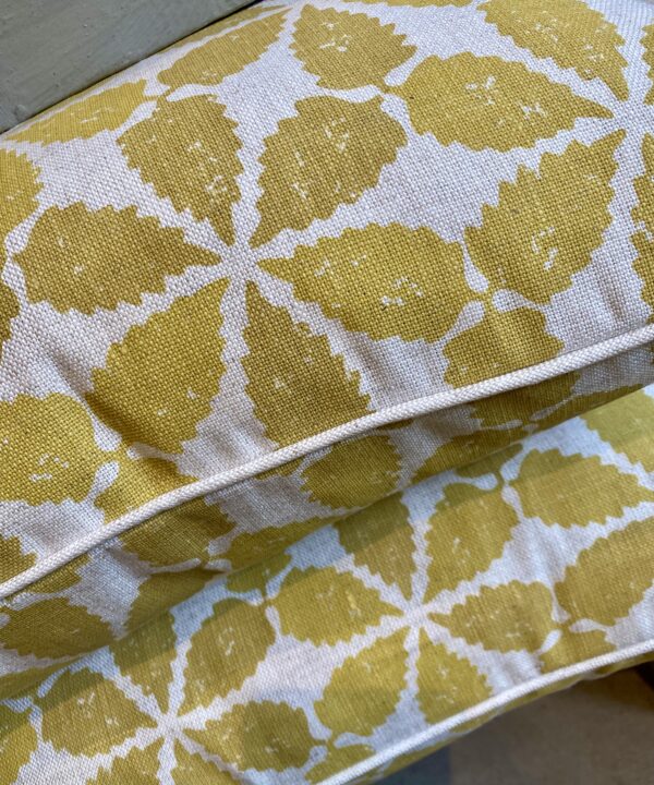 Muted yellow, hand-printed linen cushions with a Moroccan-inspired design and simple neutral piping..