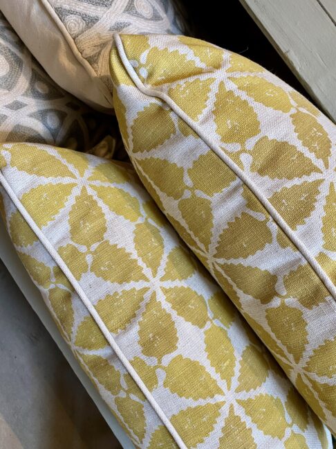 Yellow patterned cushions on hand-printed linen with a chic, Moroccan-style print design.